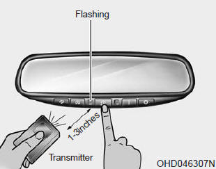 Kia Carnival: Programming. 2. Press and hold the button on the HomeLink system you wish to train and the